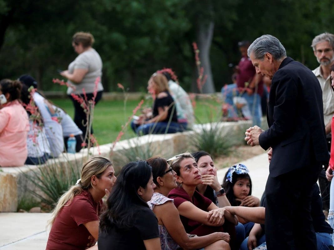 The archbishop of San Antonio, Gustavo Garcia-Siller (right), comforts families following a deadly school shooting at Robb Elementary School in Uvalde, Texas, on Tuesday.