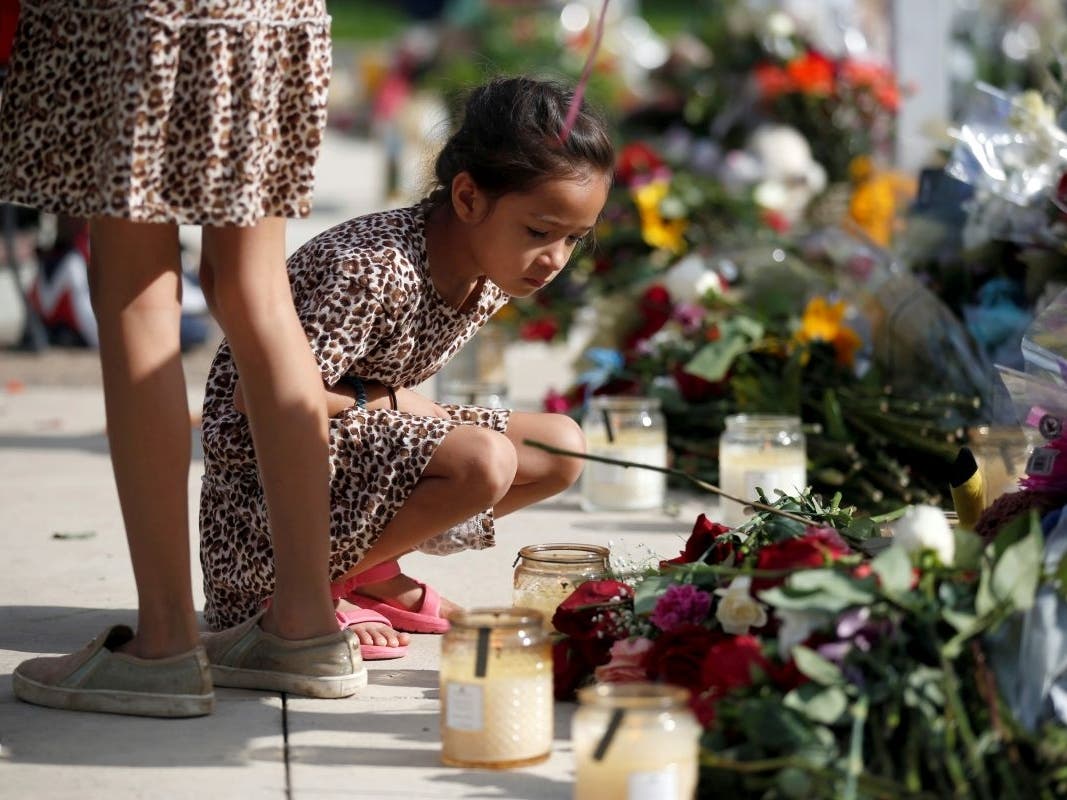 A child looks at a memorial site for the victims killed in this week's shooting at Robb Elementary School in Uvalde, Texas, on Friday.