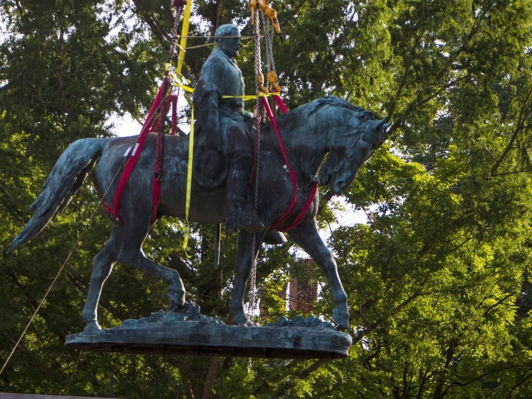 Workers remove a statue of Confederate Gen. Robert E. Lee on July 10, 2021, in Charlottesville. Initial plans to remove the statue four years ago sparked the “Unite the Right” rally in which 32-year-old Heather Heyer was killed.