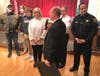 La Grange resident Betsy Buckley listens to Village President Tom Livingston during a ceremony Monday honoring her role in a rescue of a family whose car was stalled on railroad tracks. 