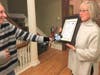 La Grange resident Betsy Buckley holds her citizen award as she is interviewed by a reporter Monday at La Grange Village Hall. She was recognized for her role in rescuing a family whose car was stalled on railroad tracks. 