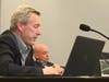 Alderman Bob Dunn explains why he is supporting a family's plan for a 49-square-foot addition. In the background is Alderman Michael Honquest, who opposed the request. 