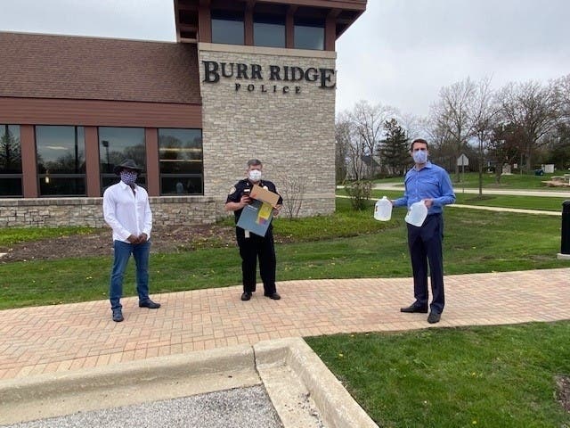 At the presentation ceremony are, from left, businessman Borris Powell, Burr Ridge Ridge Police Chief John Madden and Trustee Zach Mottl. 