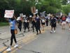 Tosin Olowu, a recent graduate of Riverside Brookfield High School, leads the march for a time on Brainard Avenue on Wednesday. 