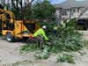 A Darien city crew works the wood chipper late Monday morning on Pinehurst Drive. 