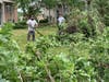 Men clear branches on Woodmere Drive in Darien late Monday morning. 