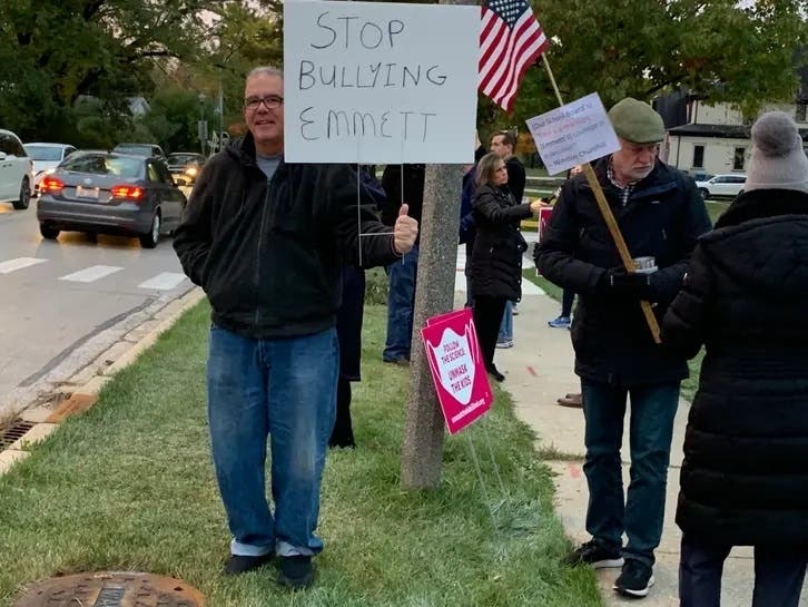 Protesters stood outside Emerson Elementary School last month to defend a fifth grader who decided to stop wearing a mask. Emerson is now seeing the biggest impact from the coronavirus among local public schools. 