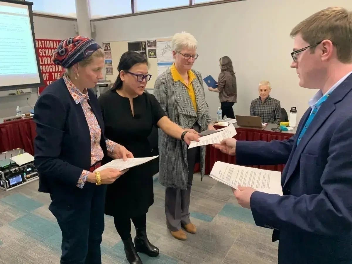 Erik Held, outgoing president of the Hinsdale High School District 86 board, prepares to administer the oath in May to members (from left) Asma Akhras, Catherine Greenspon and Kay Gallo. In resigning Thursday, Gallo criticized the board's leadership.