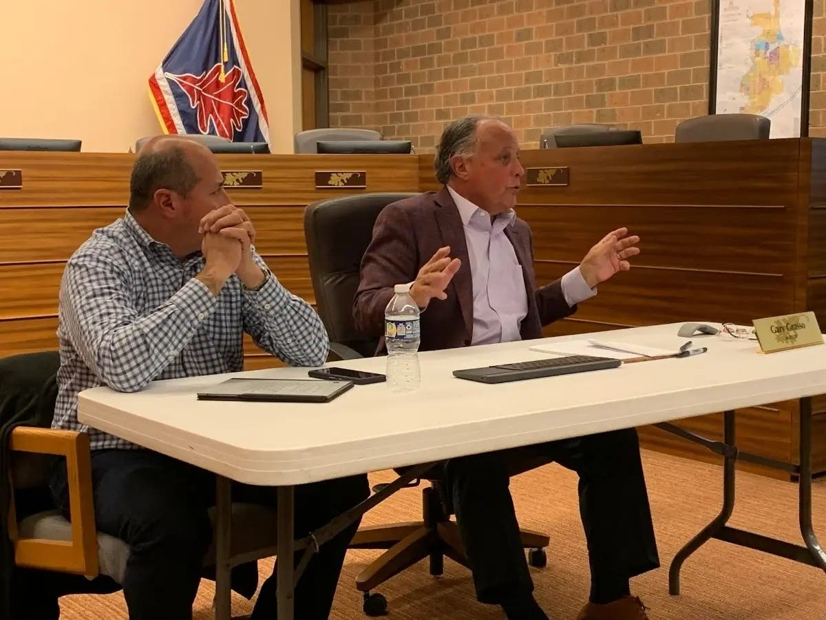 Burr Ridge Mayor Gary Grasso (right) speaks last month at a Village Hall meeting, with Trustee Tony Schiappa next to him. This week, Grasso criticized the owners of County Line Square. 