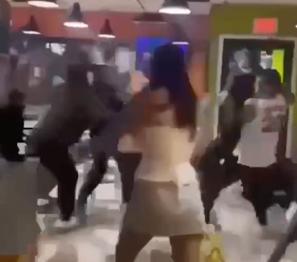 A girl can be seen watching a fight involving boys early Sunday morning at Taco Grill in Westmont. 
