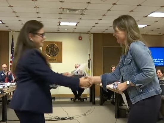 Gioia Giannotti Frye (left), who was voted in as a member of the Lyons Township High School board, shakes the hand of board President Jill Grech after taking the oath of office at Monday's board meeting.  