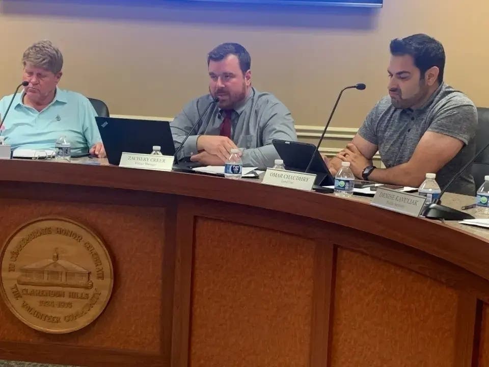 Clarendon Hills Village Manager Zach Creer (middle) speaks at a meeting in late July, not long before Village President Eric Tech (left) put him on leave. Next to them is Trustee Omar Chaudhry. 