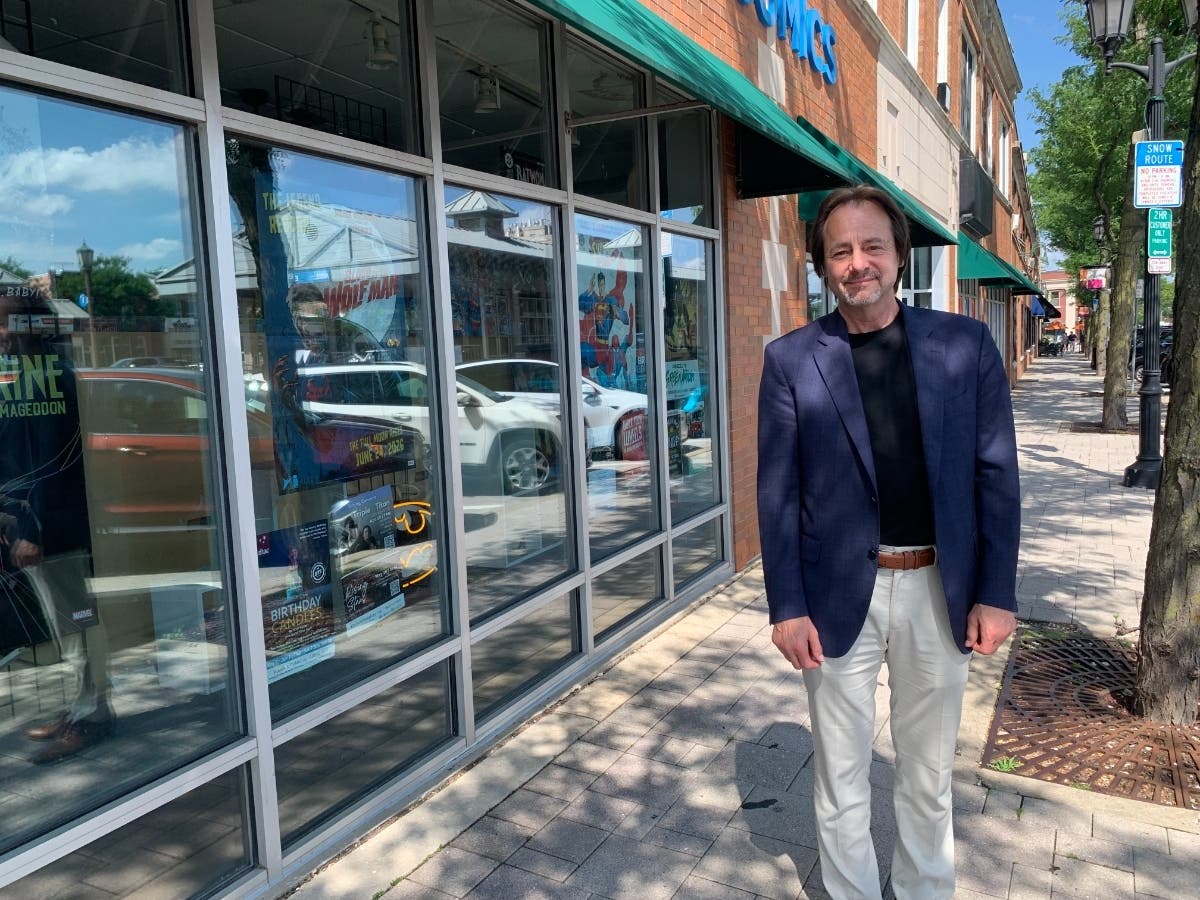 Mark George, president of Elmhurst's Encore Center for Performing Arts, stands in front of one of the buildings that would be demolished to make way for a performing arts center and apartment building. 