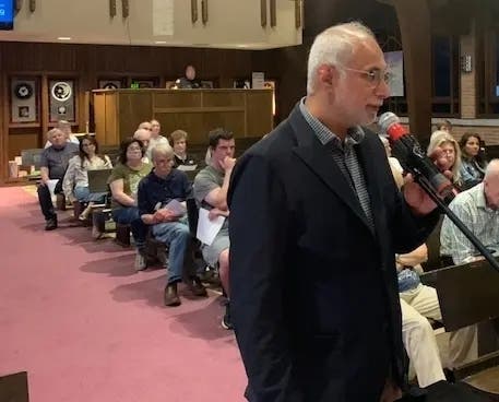 Chris Chacko, owner of Sparrow Coffee, speaks to Clarendon Hills officials at an April meeting. The village president said recently that he expected the local coffee shop to open in the "coming months."