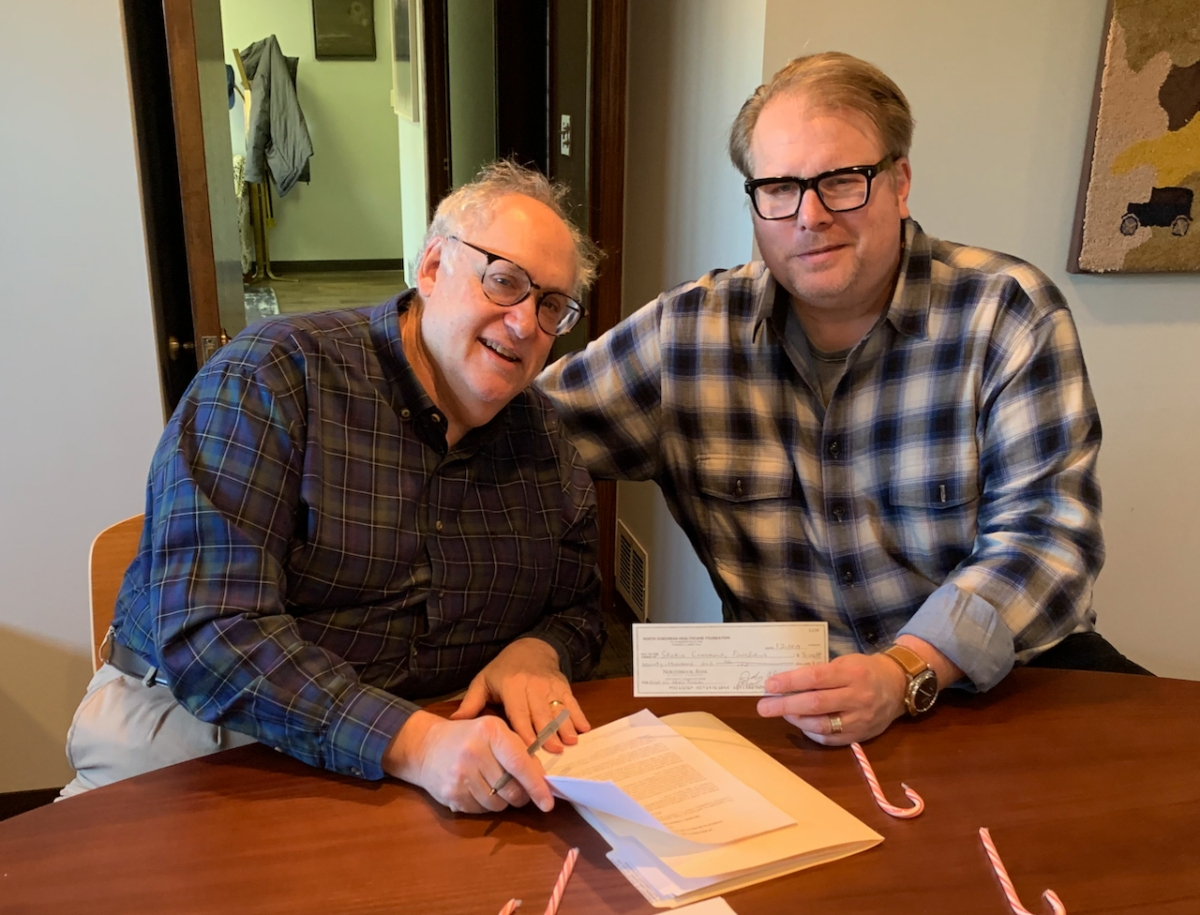 Jack Greenspan of NSHF presents SCF Board Member Zach Williams with the donation check