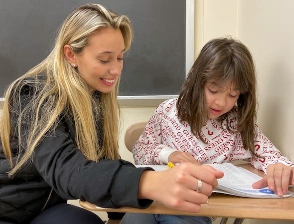 Amanta Krasniqi ’22, an adolescent education major at Iona College, reads with Valentina Oroco, a third grader at William B. Ward Elementary School in New Rochelle. 