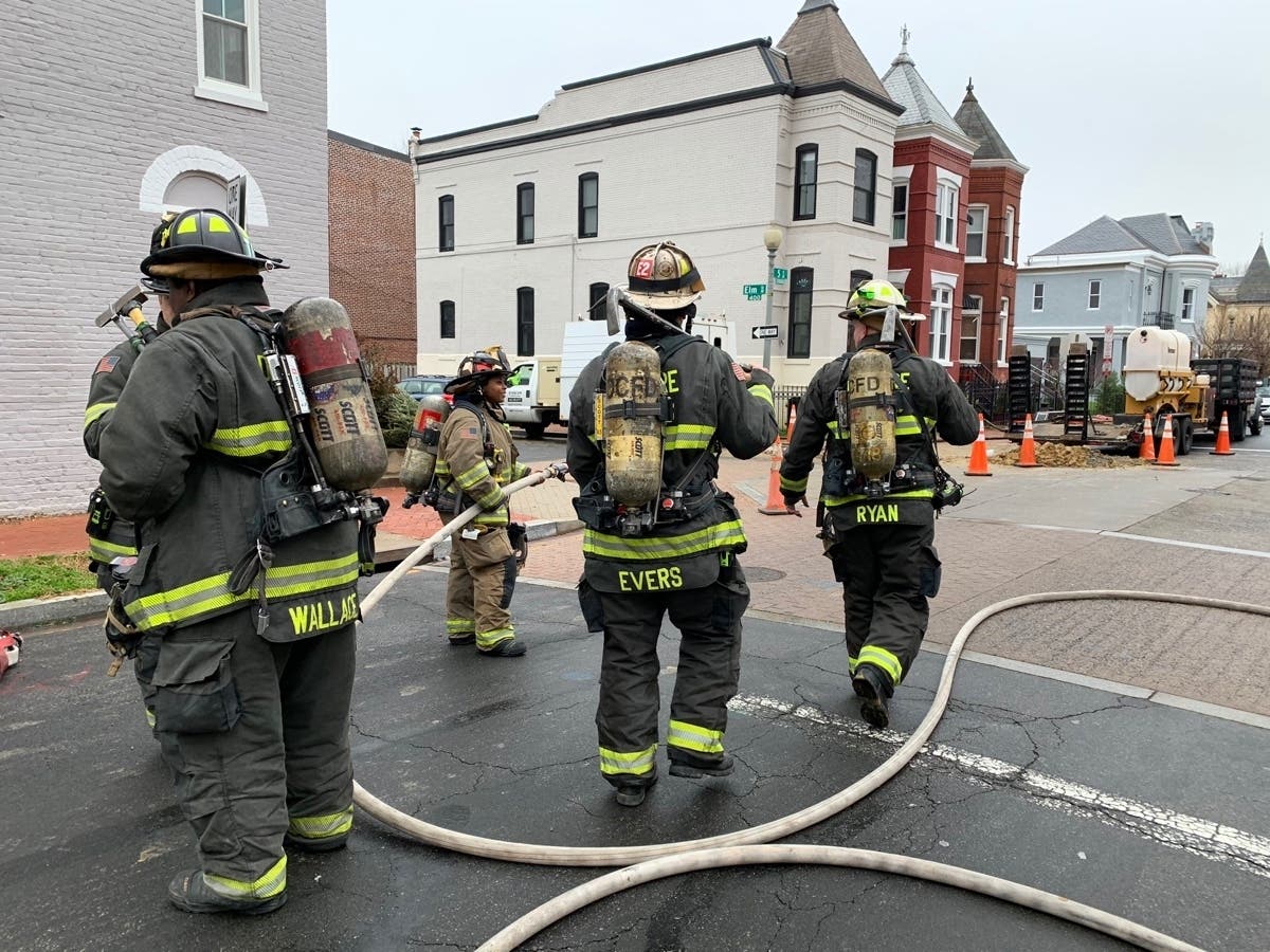 DC Fire and EMS personnel assist in the evacuation of homes Tuesday afternoon due to a gas line break.