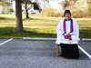 The Rev. Scott Holmer of St. Edward the Confessor Catholic Church waits Wednesday morning for parishioners to visit his outdoor confessional.