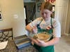  Emma Harmon of Cadette Scout Troop 1105 stirs the dough for Amish friendship/cinnamon bread to be donated to LINK.