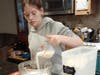 Miranda Brizzolara-Smith of Cadette Scout Troop 1105 pours milk into a bowl, as she makes Amish friendship/cinnamon bread to be donated to LINK.