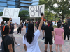 Protesters hold up signs showing support for the Black Lives Matter movement. "8:46" refers to the time in minutes and seconds of the video showing a Minneapolis police officer kneeling on George Floyd's neck. 
