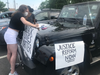 In the Herndon Middle School parking lot, a rally participant puts the final touches on signs.