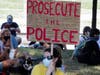 Protesters wait in the shade across the street from the National Museum of African American History and Culture.