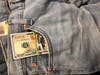 The traveler hid some of the currency in the pockets of jeans inside his checked baggage.