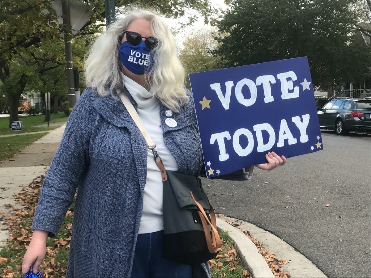 Volunteer Clair Lamb welcomes early voters to the polls Saturday at the Aurora Hills Community Center.