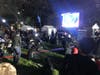 A crowd of people gathers in front of the large TV station at McPherson Square to watch the election returns.