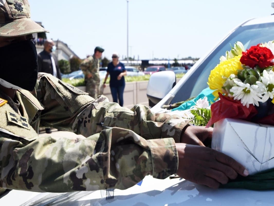 A soldier lays flowers on the hood of a Pentagon Force Protection Agency cruiser Friday afternoon during a memorial ceremony for Officer George Gonzalez in the Pentagon parking lot. 
