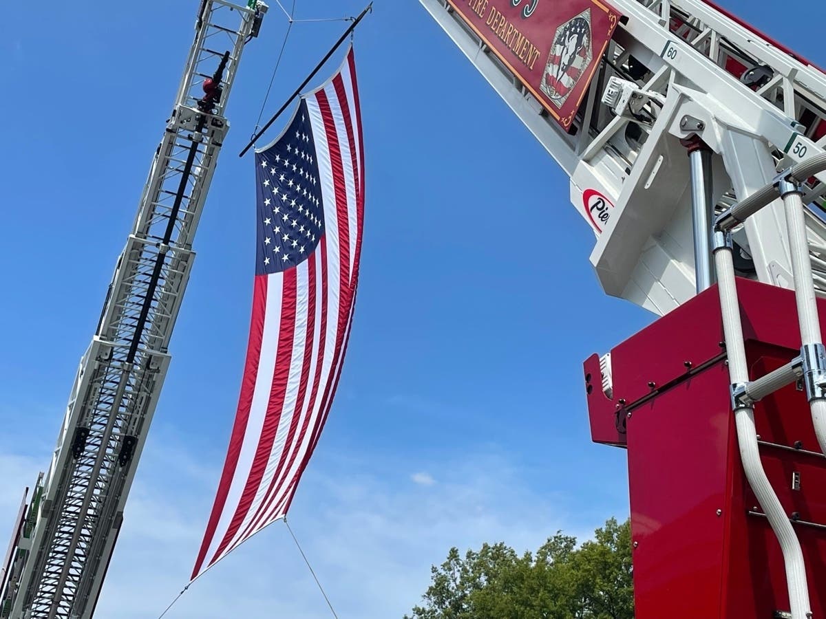 A flag flies from the ladders of two fire trucks parked in front of Fire Station 5 Saturday morning in Crystal City.