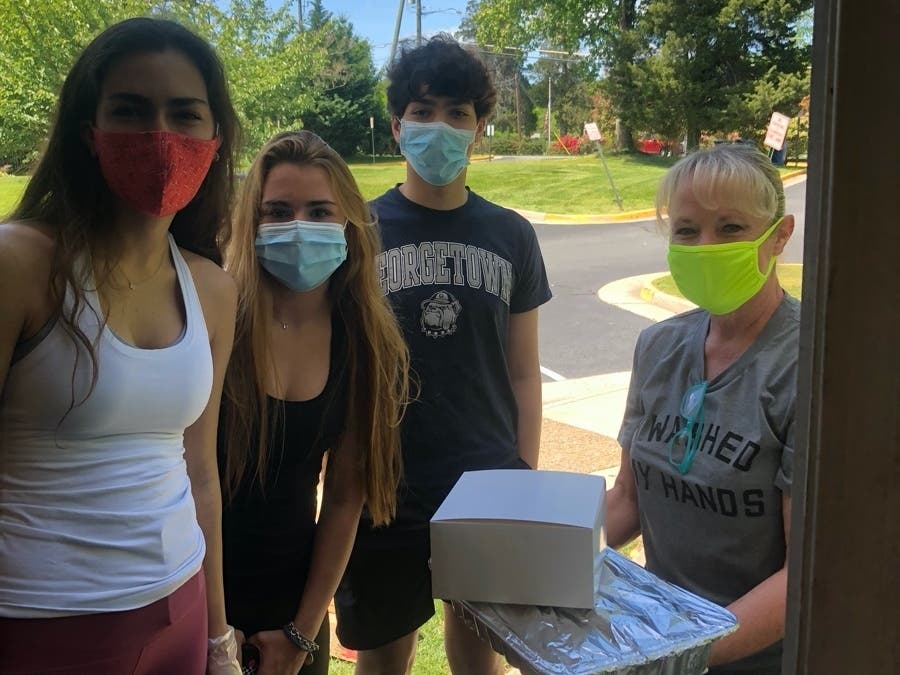 National Capital Area Council of the Boy Scouts of America is recognizing Lisa Lombardozzi of Herndon, shown here (right) delivering food to a local family, for her volunteer work at an Oct. 27 ceremony.