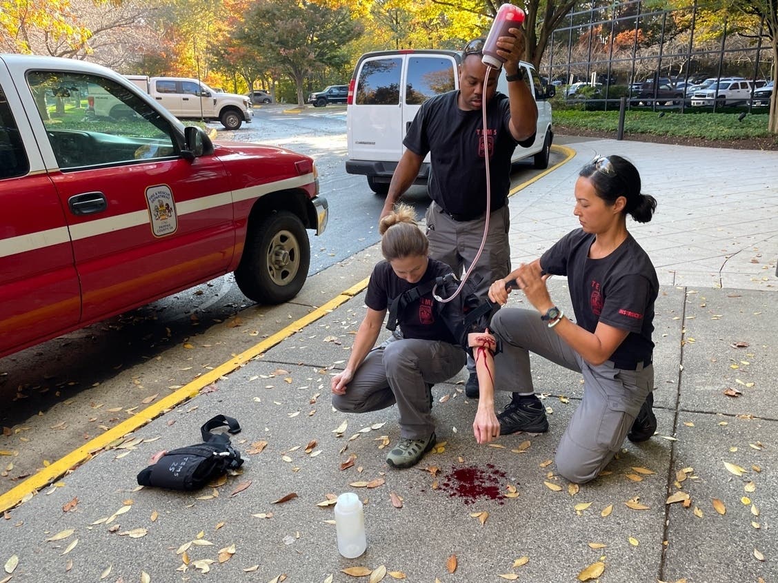 Fairfax Fire & Rescue personnel demonstrate how to apply a tourniquet Wednesday morning to someone with an injured arm. The cloth used for the tourniquet spouts fake blood to give the trainee as real an experience as possible 