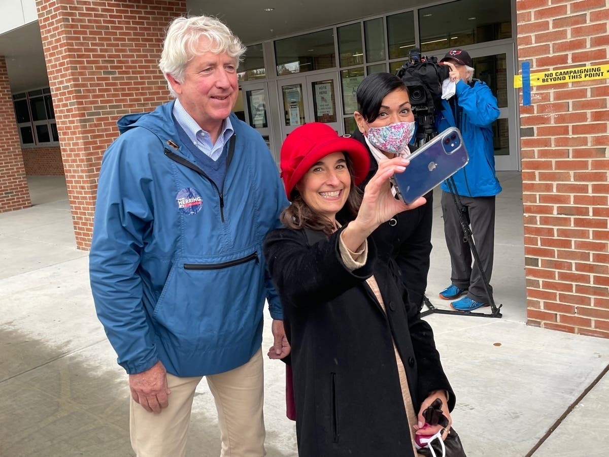 State Sen.Jennifer Boysko (center) snaps a photo with fellow Democrats Mark Herring, the former Virginia attorney general, and Hala Ayala, the party's candidate for lieutenant governor, outside the Herndon High School polls on Election Day 2021.  