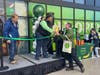 Tiffany Pressley, manager of Fairfax Amazon Fresh, gives a bouquet of flowers and a $250 gift card to Fairfax City resident Thomas Castro, who was first in line waiting for the opening of the new grocery store in the Point 50 shopping center.