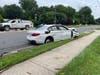 The white BMW involved in the two-vehicle crash came to rest on the sidewalk about 100 feet south of Five Oaks Road on Blake Lane.
