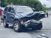 An SUV with its frontend smashed in sits at the intersection of Blake Lane and Five Oaks Road following a collision that killed two Oakton High School students and injured a third student.