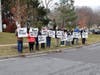 Former students of Vincent Gibbs hold up posters on Saturday to show the 86-year-old former English and drama teacher how much he influenced their lives.