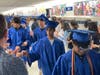 Fairfax High School seniors receive fist bumps from students at Katherine Johnson Middle School during Monday's graduation walk.