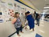 A Fairfax High School senior stops to hug one over her former teachers during Monday's graduation walk at Katherine Johnson Middle School.