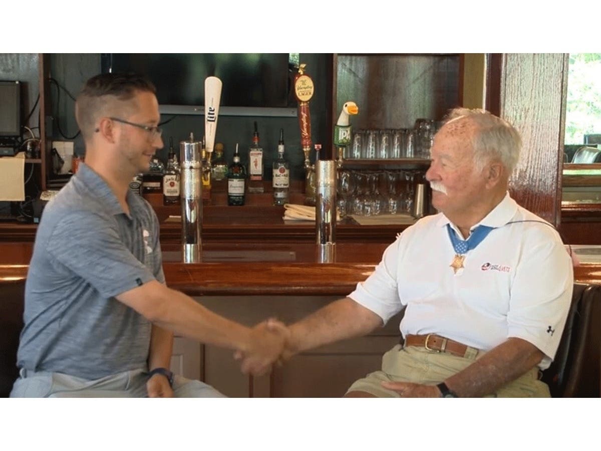 After breaking the course record for most holes played in a day at Hidden Creek Country Club on Friday, Anthony McNamara (left) receives a handshake from retired U.S. Marine Corps Col. Barney Barnum.