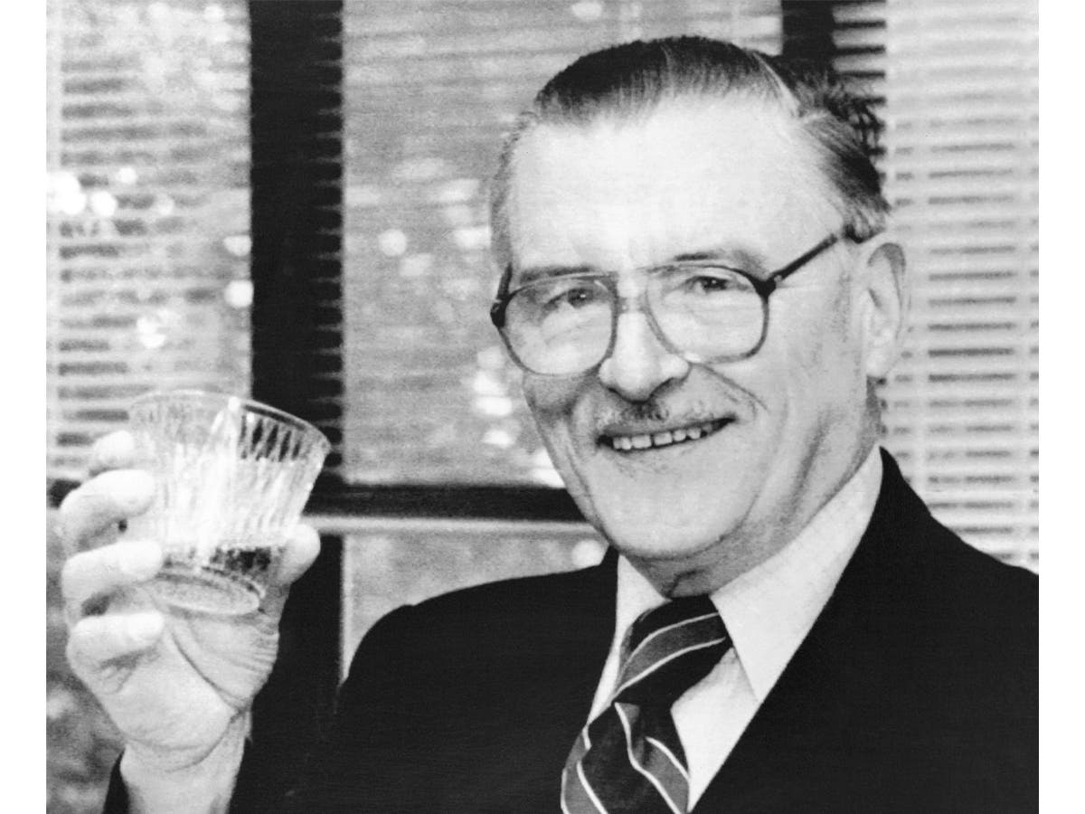 James McGill Buchanan, winner of the Nobel Memorial Prize in Economic Science, holds up a glass of champagne in his office in George Mason University on Oct. 16, 1986.