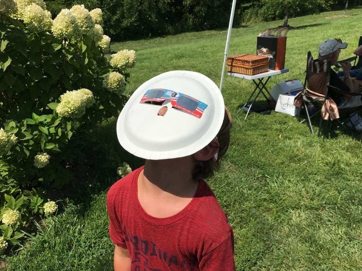 A student in Marthasville, Missouri uses an improvised viewer to check out the 2017 solar eclipse.