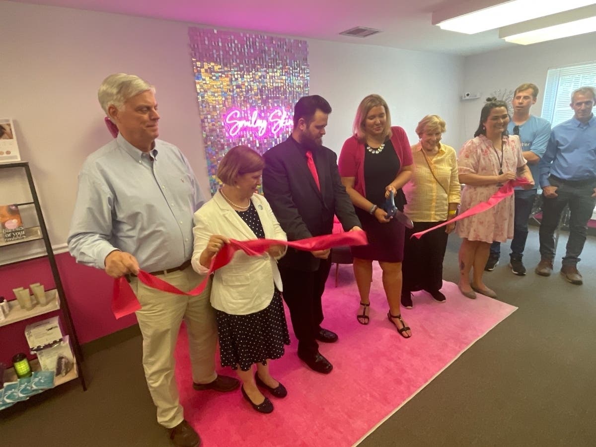 Cutting the ribbon are (From Left) Commissioner of Revenue Page Johnson; Mayor Catherine Reed; Ben Dallojacono, the owner's husband; Smiley Skin owner Stephanie Dallojacono; Tara Borwey, the EDA programs manager; and Susan Schulz, the owner's grandmother.
