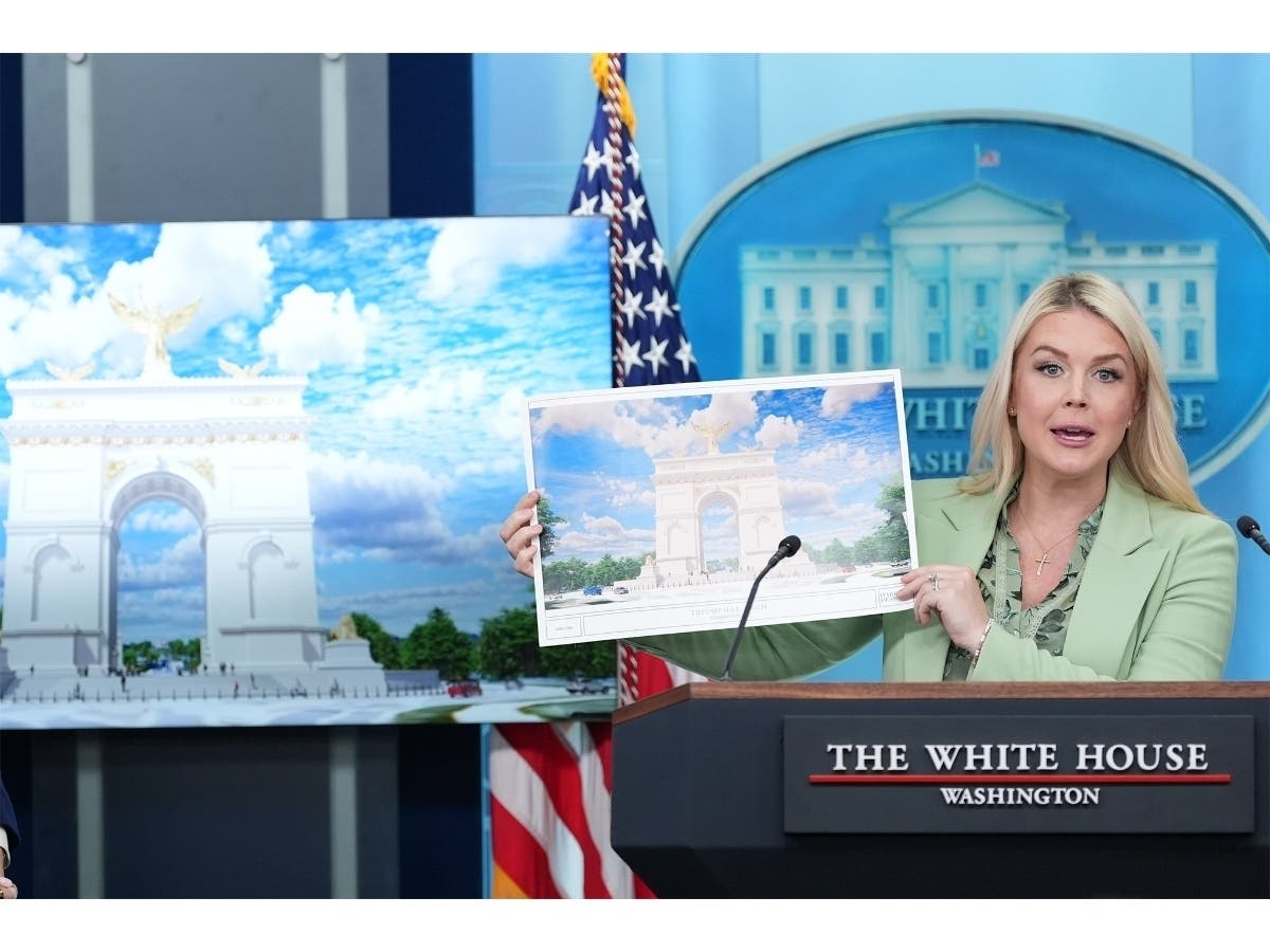 White House press secretary Karoline Leavitt holds up an artist rendering of the new triumphal arch as she speaks with reporters in the James Brady Press Briefing Room at the White House, Wednesday, April 15, 2026, in Washington, D.C.