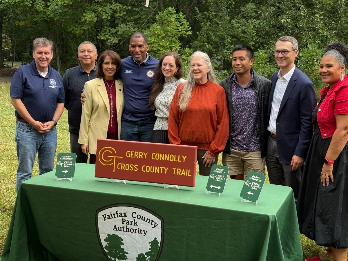 Members of the Fairfax County Board of Supervisors and Fairfax County Park Authority join the widow and daughter of former U.S. Rep. Gerry Connolly to unveil new signs for the 41.5 Cross County Trail which bears the late congressman's name.