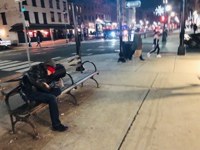 A man sleeps on a bench on Washington Street in Hoboken Thursday evening. Temperatures were in the 40s.