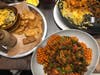 Just some of the unique Indian dishes at Curry Up -- a mac and cheese kids' meal with chocolate milk, the "Sexy Fries" with potato and peas, and one of the paneer bowls. 