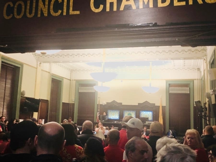 Droves of Hoboken City Hall workers in red shirts packed the council chambers for a meeting on Wednesday night. Their attorney had said that talk of layoffs was meant to push them into accepting a 'substandard' health plan.